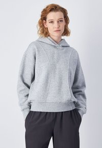 Sudadera con capucha gris de corte holgado, fabricada con un tejido texturizado, puños acanalados y un dobladillo recortado. Detalles cosidos en la parte frontal.