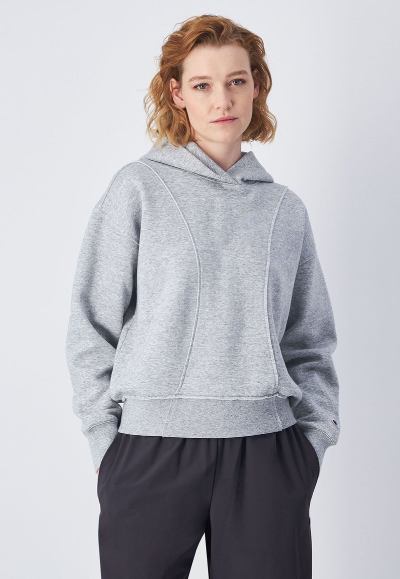 Sudadera con capucha gris de corte holgado, fabricada con un tejido texturizado, puños acanalados y un dobladillo recortado. Detalles cosidos en la parte frontal.