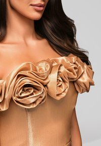 Abito in satin con dettagli floreali tridimensionali in un morbido colore beige, che mette in risalto il tessuto stratificato e testurizzato e una silhouette aderente.
