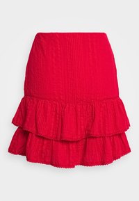 Mini-jupe rouge texturée avec ourlet à double volants et subtils détails en dentelle, ajustée à la taille et évasée au bas.