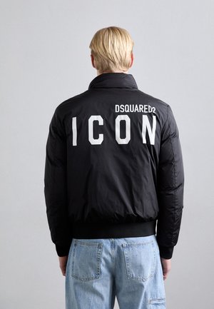 Giacca a vento nera con collo alto, caratterizzata da testo bianco "ICON" e logo "DSQUARED2" sulla schiena. Polsini e cintura a coste.