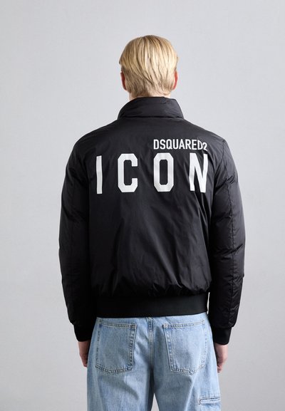 Doudoune noire avec col montant, ornée du texte blanc "ICON" et du logo "DSQUARED2" au dos. Manches côtelées et taille élastiquée.