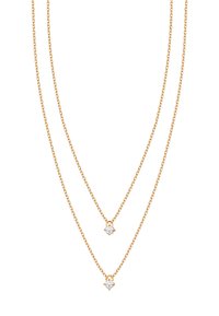 Złota, wielowarstwowa naszyjnik z dwiema delikatnymi łańcuszkami, zdobiony dwoma małymi, okrągłymi, przezroczystymi kamieniami jako wisiorkami, prezentujący minimalistyczny design.