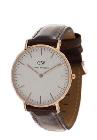 Brązowy skórzany zegarek na pasku z białą tarczą, obudowa w kolorze różowego złota, minimalistyczne znaczniki oraz nazwa marki "Daniel Wellington".