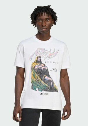 White cotton T-shirt featuring a colorful graphic print of a cloaked figure, with text and logos at the bottom. Casual fit with short sleeves.