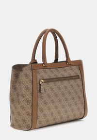 Sac fourre-tout à motif marron avec garniture en cuir, poignées doubles et poche zippée externe sur fond uni.