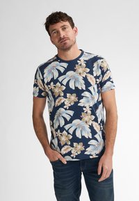 Lyhythihainen tummansininen t-paita, jossa on kukkakuosi, jossa on vaaleansiniset ja beige lehdet sekä kermaisenvalkoisia kukkia. Pyöreä kaula-aukko ja pehmeä kangas.