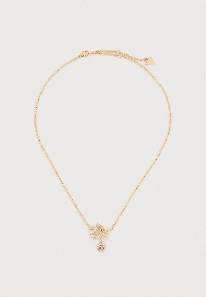 Κολιέ σε χρυσό τόνο με λεπτή αλυσίδα, που διαθέτει μενταγιόν σε σχήμα καρδιάς διακοσμημένο με μικρές πέτρες και στρογγυλή διακοσμητική λεπτομέρεια.