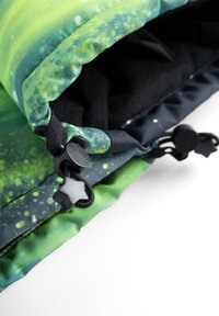Grüner und schwarzer Stoff mit Muster und glatter Textur, ausgestattet mit einem Kordelzugverschluss und einem sternförmigen Hardware-Detail.