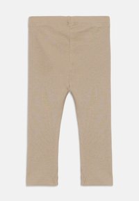 Beige ribbestrikkede leggings laget av mykt materiale, med en tettsittende passform, rette ben og små splitt ved ermet for ekstra detaljer.
