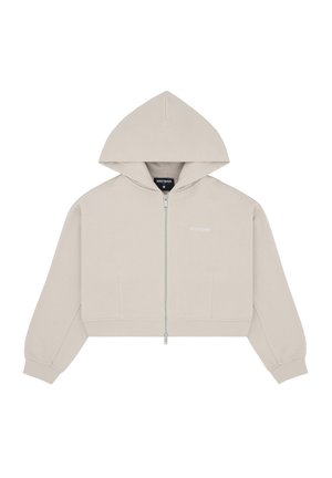 Light beige cropped zip-up hoodie with long sleeves, front pockets, and a small "WRSTBHVR" logo on the chest and inside collar.