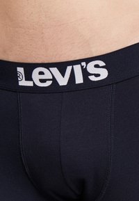 Marineblauwe Levi's boxershorts met een witte logoband. Kenmerkt zich door een gladde textuur en een nauwsluitend ontwerp, waarbij de stikseldetails zichtbaar zijn.
