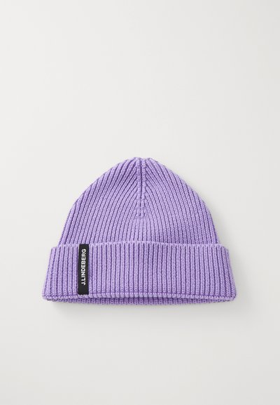 Berretto a maglia viola con texture a coste e risvolto. Presenta un'etichetta nera con testo bianco sul lato.