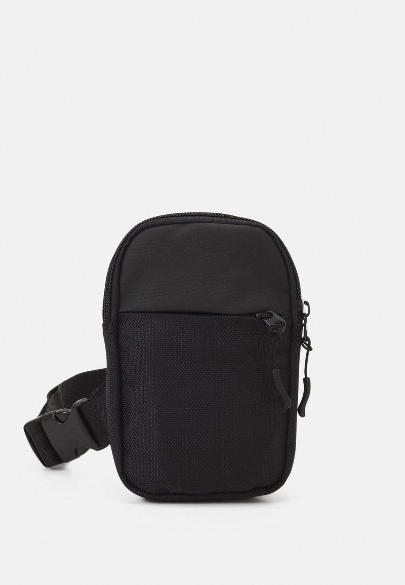 Sac bandoulière noir compact avec poche zippée à l'avant et sangle réglable, conçu pour un usage quotidien et un rangement sécurisé.