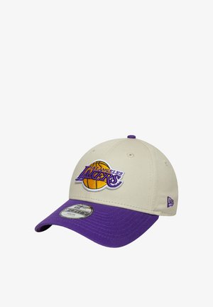 Gorra beige con visera morada y logo bordado de Los Angeles Lakers. Presenta un frente estructurado, seis paneles y una visera plana.