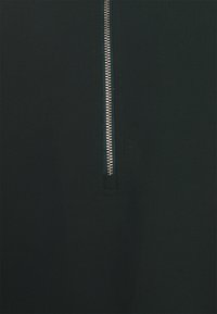 Tessuto verde scuro con una texture liscia, caratterizzato da una zip parziale con finitura metallica al centro per la chiusura.