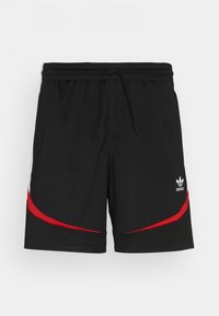 Pantaloni sportivi neri con accenti curvi rossi e bianchi, vita elastica, coulisse e un piccolo logo bianco nella parte anteriore inferiore.