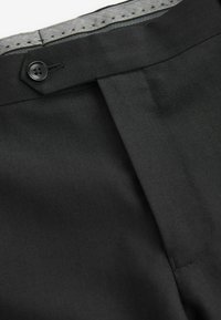 Schwarze maßgeschneiderte Hosen mit Fischgrätenmuster, ausgestattet mit einem Frontknopfverschluss und sauber gesteppten Details entlang des Bunds.