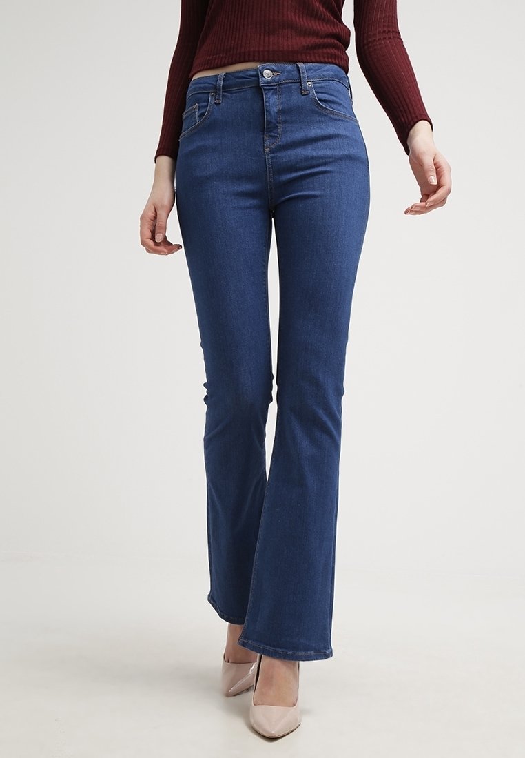 Mörkblå utsvängda jeans i denim, med klassisk femfickdesign, metallknapp och sydda sömmar.