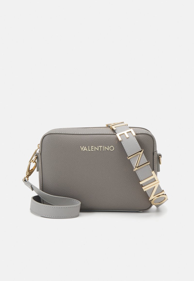 Sac en cuir gris à bandoulière avec logo "VALENTINO" en ton doré, strap ajustable et fermeture éclair, avec une finition texturée et une forme rectangulaire.