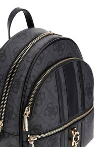 Zaino nero con texture, dotato di doppi zip dorati, dettagli in pelle e un logo prominente sul davanti; forma arrotondata e motivo sottile.