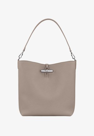 Beige leather handbag with a smooth texture, top magnetic closure, and a single shoulder strap. Features silver-tone hardware accents.