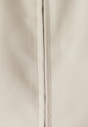 Beige fabric with a smooth texture, featuring a central zipper with metallic detailing and reinforced seams on either side.