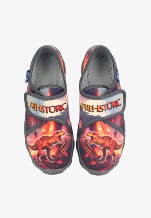 Textiel schoenen met een levendige dinosaurustextuur in rood en oranje tegen een donkere achtergrond. Verstelbare band met het label "PRE-HISTORIC".