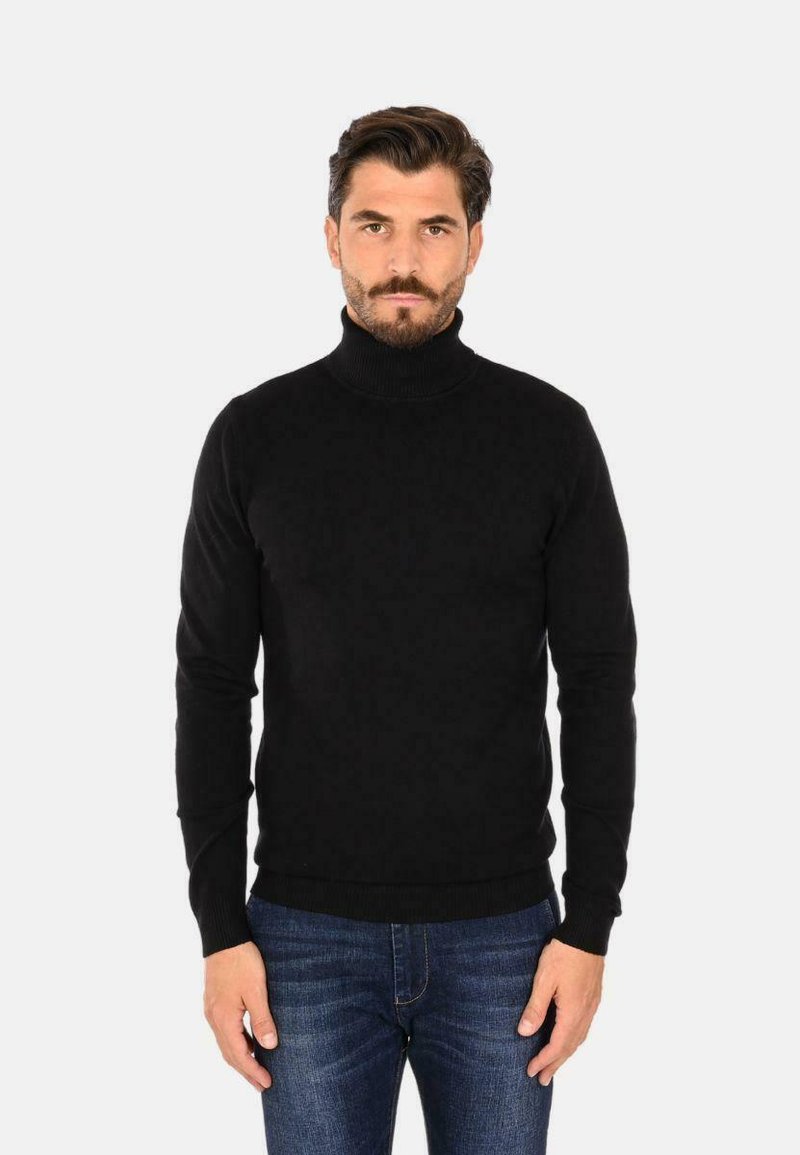 Maglione aderente nero a collo alto realizzato in morbido materiale, caratterizzato da una silhouette slim e orli e polsini a coste, abbinato a jeans blu.