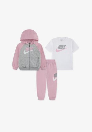 Nike children’s outfit featuring a pink and gray zip-up hoodie, matching pink sweatpants, and a white T-shirt with gray logo.