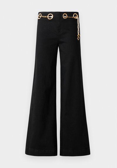 Czarne spodnie szerokie w nogawkach wykonane z bawełny, z pozłacanym okrągłym elementem dekoracyjnym i detalem w postaci łańcuszka na pasku. Gładka faktura, czysty krój.