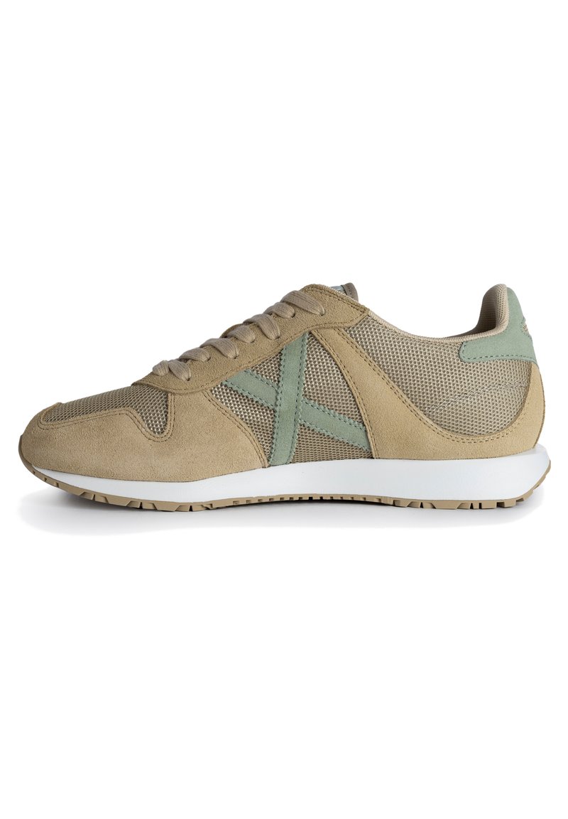 Zapatillas de ante y malla beige con detalles en verde menta, cordones planos, suela blanca acolchada y una suela exterior de goma texturizada.