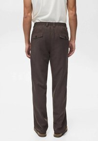 Braune Baumwollhose mit lockerer Passform, ausgestattet mit einem dehnbaren Bund, zwei Gesäßtaschen und dezenter Textur.