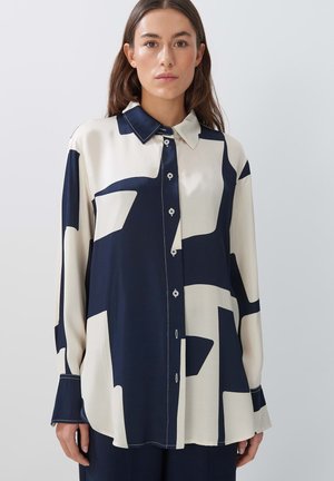 Hemd mit abstraktem Muster in Marineblau und Creme, mit Kragen, durchgehender Knopfleiste, langen Ärmeln und glatter Stofftextur. Sichtbare Akzentknöpfe.