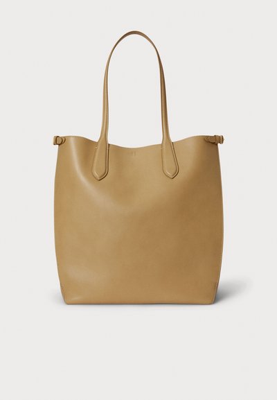 Torba za na ramo iz prešite rjave usnje, z zaobljenimi robovi, dvema dolgima ročajema in minimalističnim dizajnom. Gladek tekstura z diskretnimi šivi.