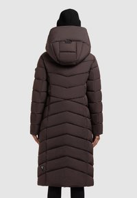 Brun pufferjakke med chevron-mønster, polstret design og en rummelig, fasthæftet hætte. Har et logo-patch på den nedre side.