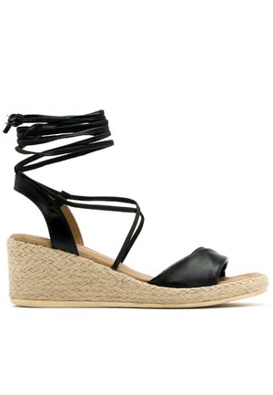 Czarne skórzane sandały na koturnie z plecioną jucie podeszwą oraz paskami na kostce, z odkrytymi palcami i niskim obcasem, odpowiednie do codziennych stylizacji.