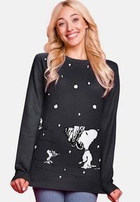 Black knitted sweater featuring a white snow scene with characters, round neckline, and long sleeves. Soft texture and relaxed fit.