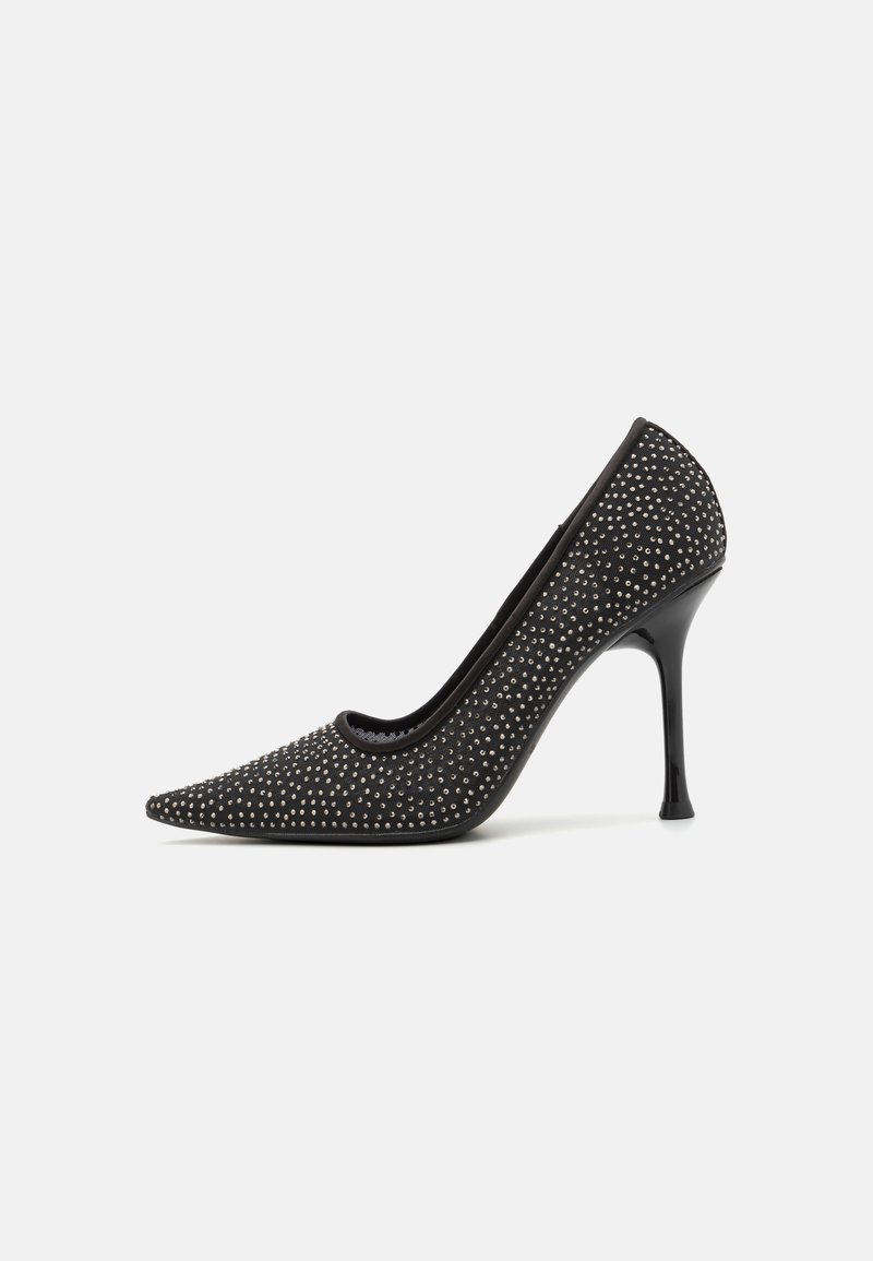 Escarpin noir à talon haut avec un bout pointu, orné de petites rivets en argent, présentant une tige texturée et un talon aiguille élégant.