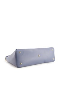 Light blue leather handbag with a smooth texture, rectangular shape, and gold-colored metal studs. Features a structured bottom for stability.