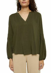 Blouse olive verte à manches longues avec un décolleté en V et des manches froncées ; tissu léger avec de subtils rayures verticales et coupe décontractée.