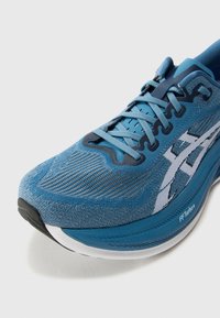 Blue athletic shoe featuring a textured synthetic upper, contrasting white logo, and a thick sole labeled "FF Turbo+" with a rubber outsole.