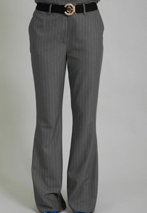 Maßgeschneiderte graue Nadelstreifenhose mit leicht ausgestelltem Bein, getragen mit einem schwarzen Gürtel mit goldener runder Schnalle, kombiniert mit blauen Schuhen.