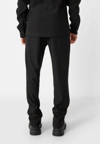 Zwarte ribbelstof broek met een rechte pasvorm, voorzien van een soepele textuur en subtiele glans. Gemaakt in combinatie met een bijpassend langemouwen top.