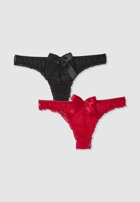 Due paia di perizoma in pizzo, uno nero con un fiocco di raso e bordi arricciati, e uno rosso con dettagli simili, sovrapposti su uno sfondo bianco.