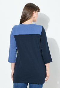 Marineblau und hellblau colorblock Langarmshirt, mit Rundhalsausschnitt und lockerer Passform, aus weichem Baumwollmaterial gefertigt.