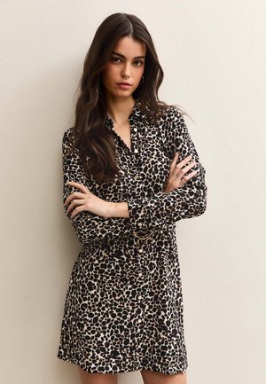 Leopard print shirt dress in beige and black, featuring a button-down front, long sleeves, and a relaxed fit. Soft fabric with a smooth texture.