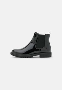 Bottines en cuir verni noir avec panneaux latéraux élastiques, bout arrondi et semelle en caoutchouc texturée. Elles sont dotées d'une languette au talon.