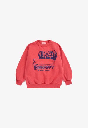 Sweat-shirt rouge à manches longues avec un motif abstrait bleu marine sur le bras et le texte "BIGFOOT by BOBO CHOSES" sur le devant.