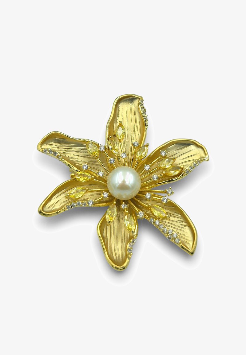 Broche floral en or avec des pétales texturés, des pierres précieuses jaunes et blanches, et une grosse perle centrale.